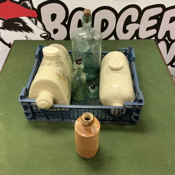 Vintage bottle collection including R Whites bottle and ceramic foot warmers.