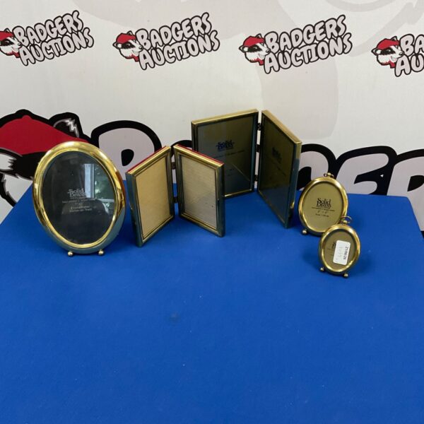 Vintage brass photo frames displayed on a patterned surface.