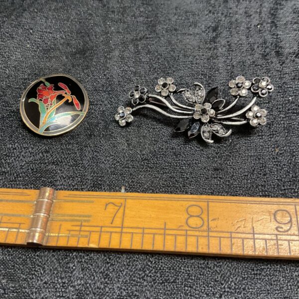Vintage brooches pair featuring enamel floral and stone flower designs.