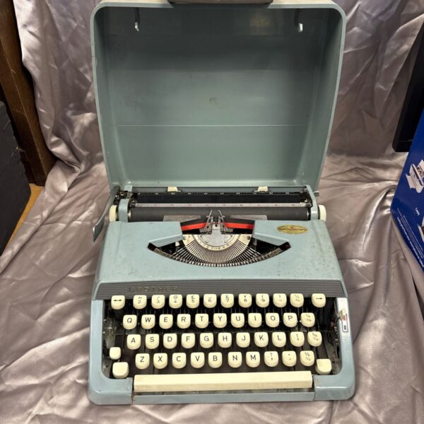 Vintage green Brother portable typewriter, side view.