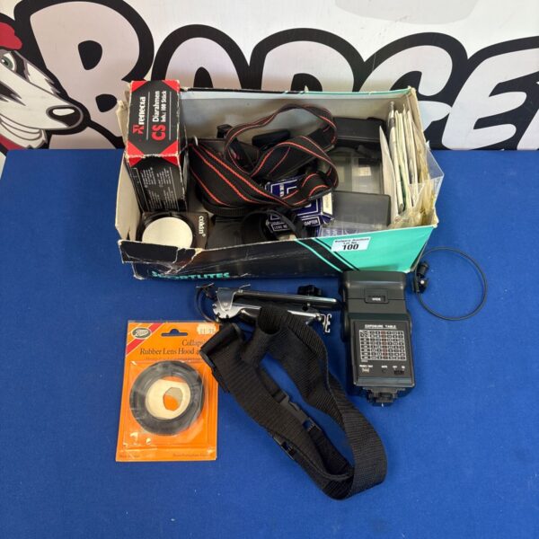 Box of vintage camera accessories including a Jessops flash unit.