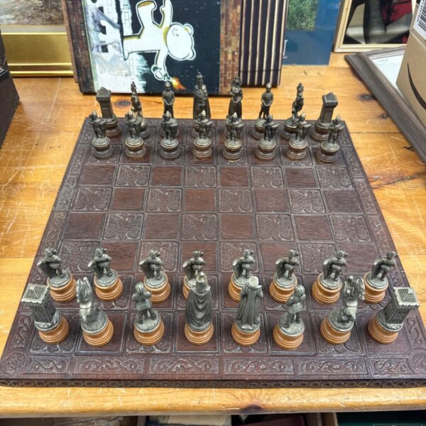 Vintage carved wooden chess set with metal medieval pieces.