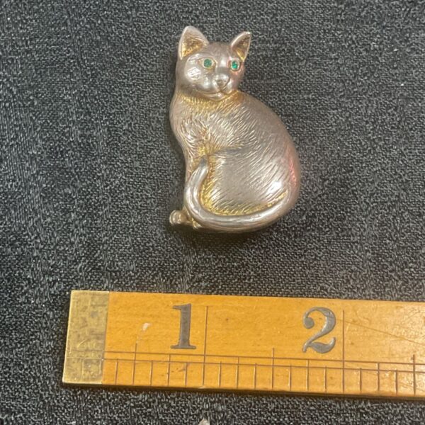 Vintage silver cat brooch with emerald green eyes.
