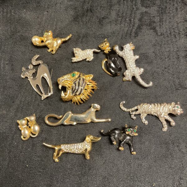 Vintage cat brooches and a dog pin in a collectible lot.