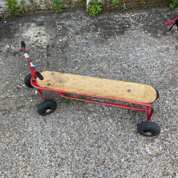 Vintage children's scooter with wooden deck and metal frame.