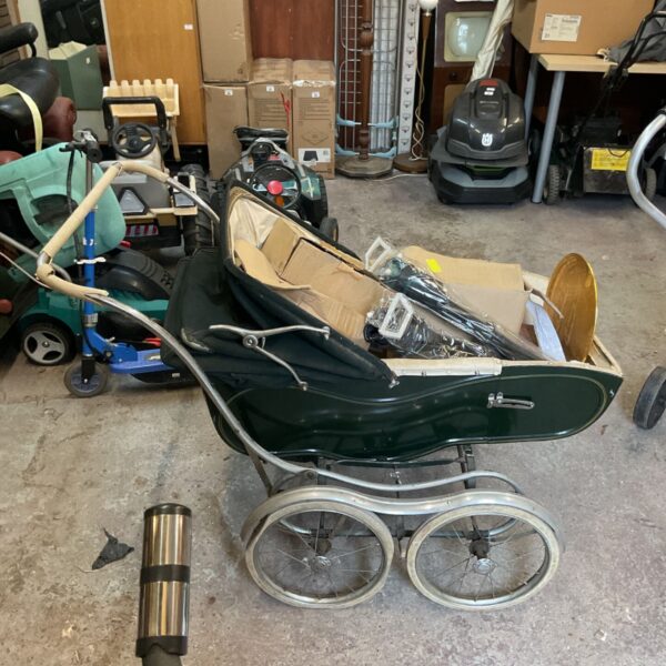 Vintage green child's pram with woven basket interior.