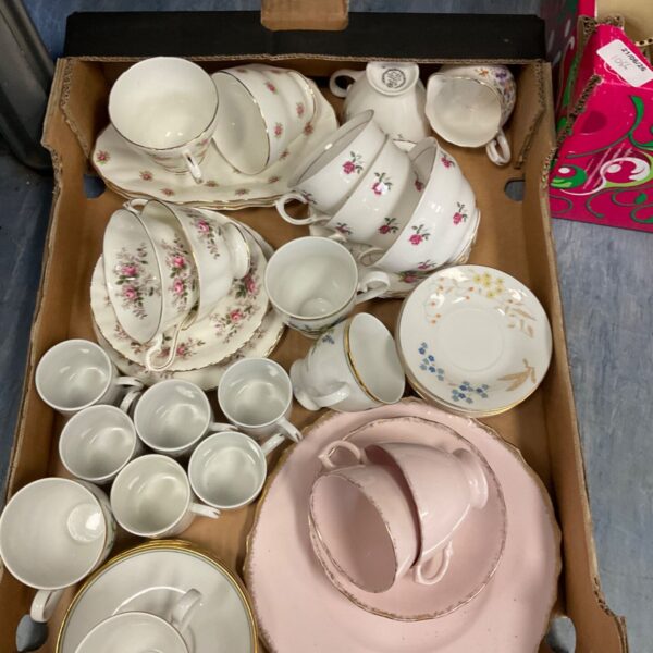 Vintage china tea sets with floral pattern on display.