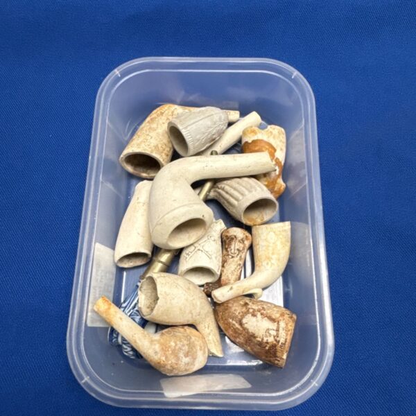 Tray of assorted vintage clay pipe bowls for collectors.