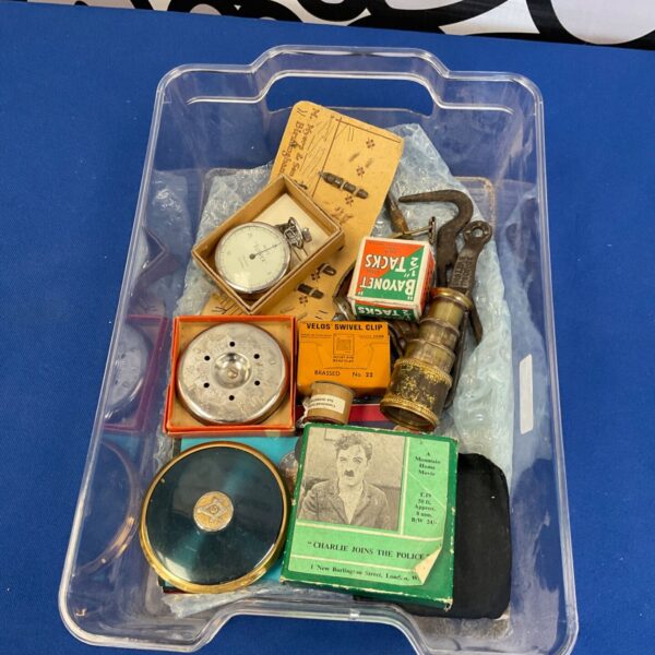 Vintage collectibles lot featuring a brass pocket watch and film reel.