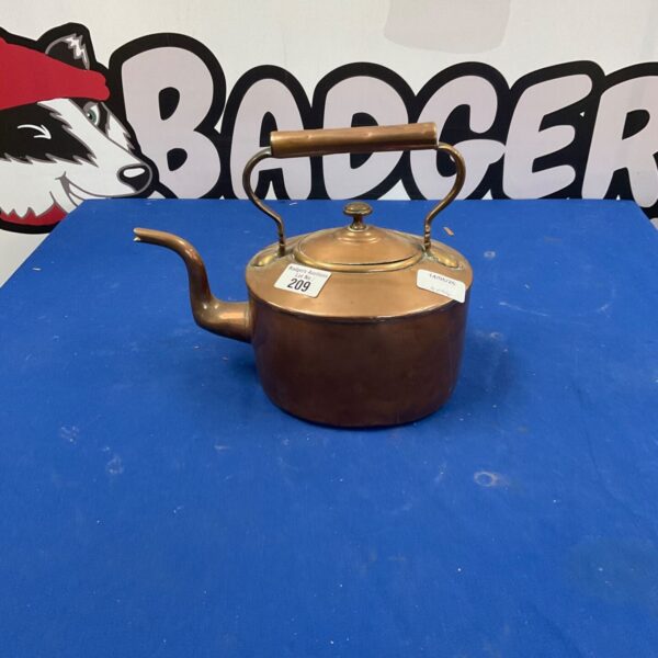 Vintage copper teapot with a curved spout and handle.