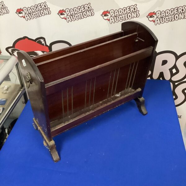 Vintage dark wood magazine rack for storing magazines.