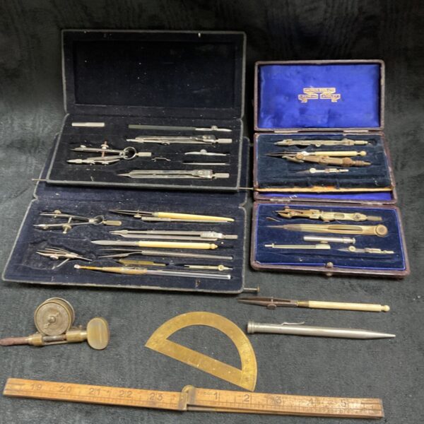Vintage drawing instrument sets and bell revolution counter displayed.
