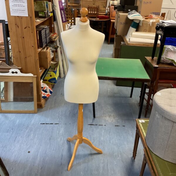 Vintage dressmaker’s mannequin on wooden stand for sewing and display.