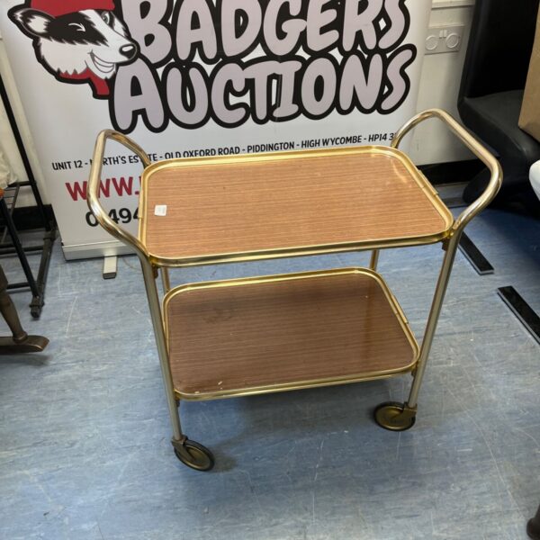 Vintage gold drinks trolley with wood-effect shelves.