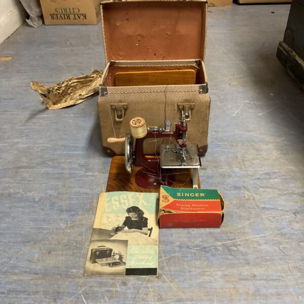 Vintage Essex miniature sewing machine in a patterned case.