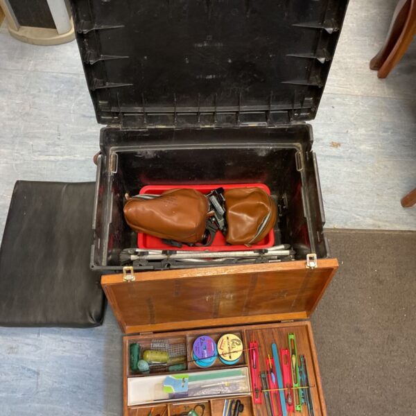 Open vintage fishing tackle box with fishing gear inside.