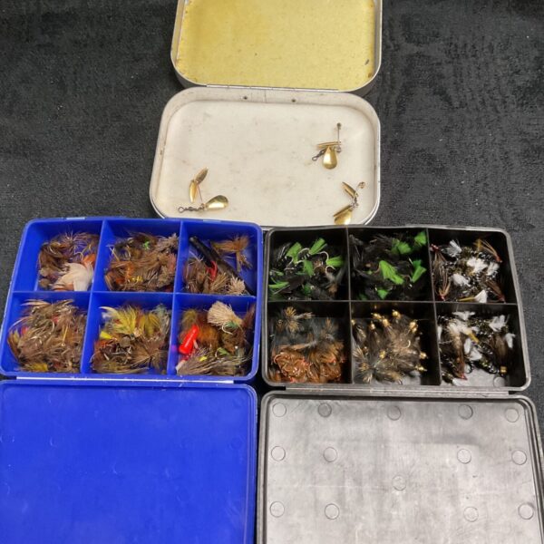 Vintage fly fishing tackle boxes filled with trout flies and lures.