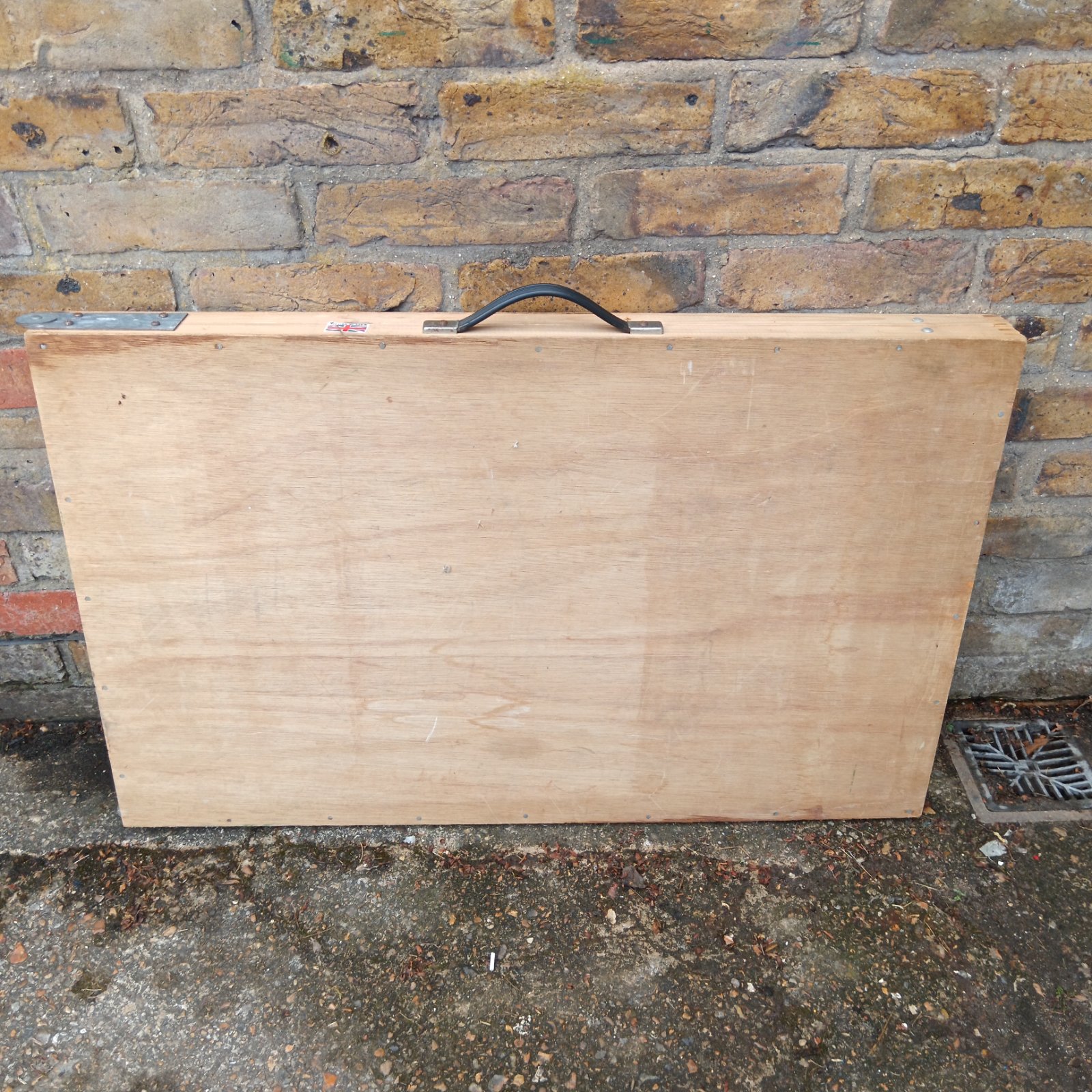 Vintage folding pasting table with wooden construction and carrying handle.
