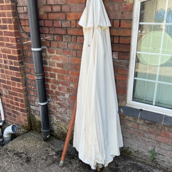 White vintage garden parasol standing outdoors.