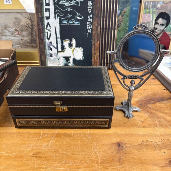 Vintage jewellery box and mirror set on wooden surface.