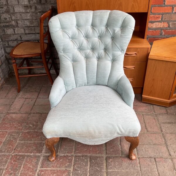 Light blue vintage button back armchair in a room setting.