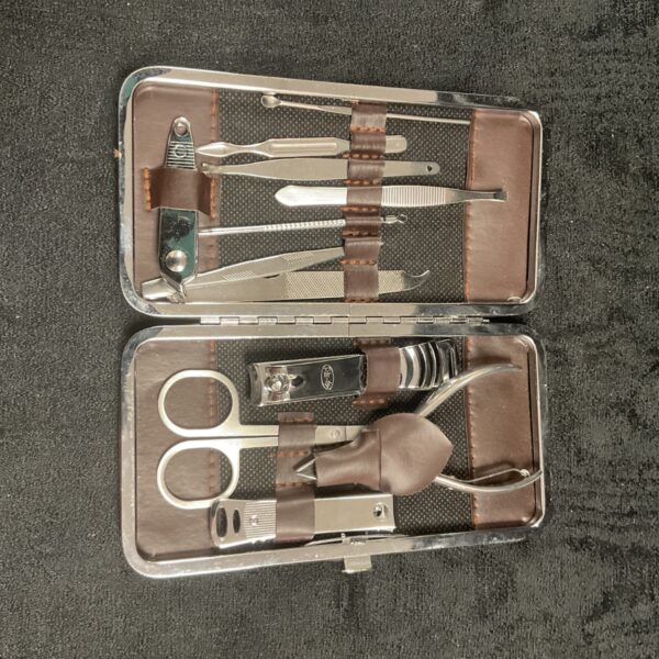 Open vintage manicure set with silver tools in leather case.