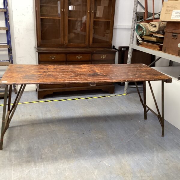 Vintage military folding table with weathered wooden top.