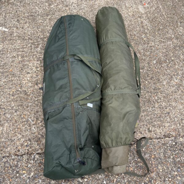 Two vintage military tents rolled in their canvas storage bags.