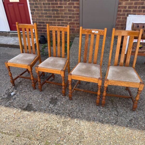 Set of four vintage oak dining chairs in a home setting.