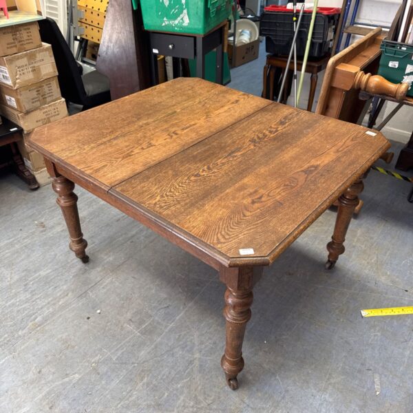 Vintage oak dining table with a worn surface and turned legs.