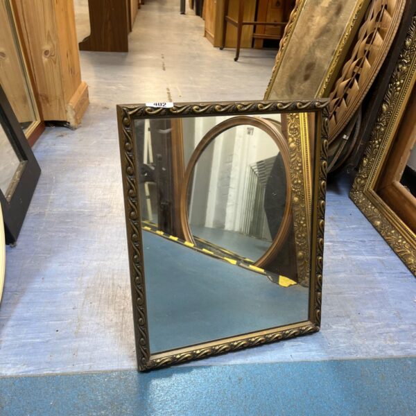 Vintage ornate wall mirror with detailed gold frame.