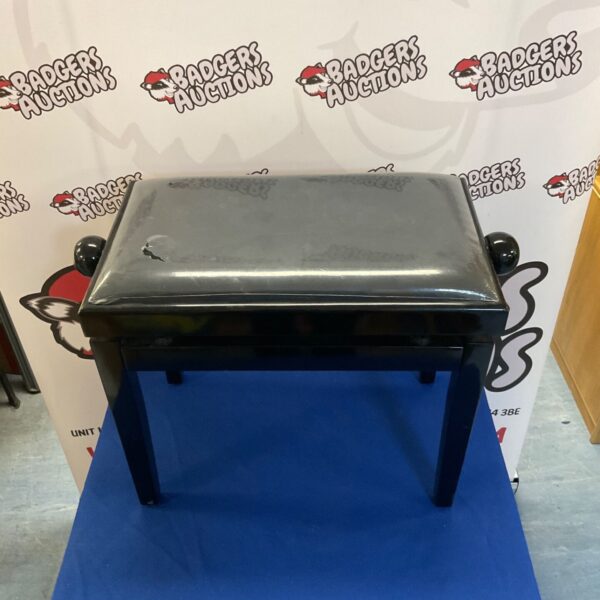 Dark upholstered vintage piano stool with wooden legs.