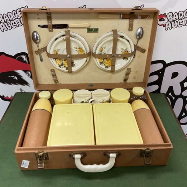 Vintage picnic set in a brown suitcase with china and flasks.