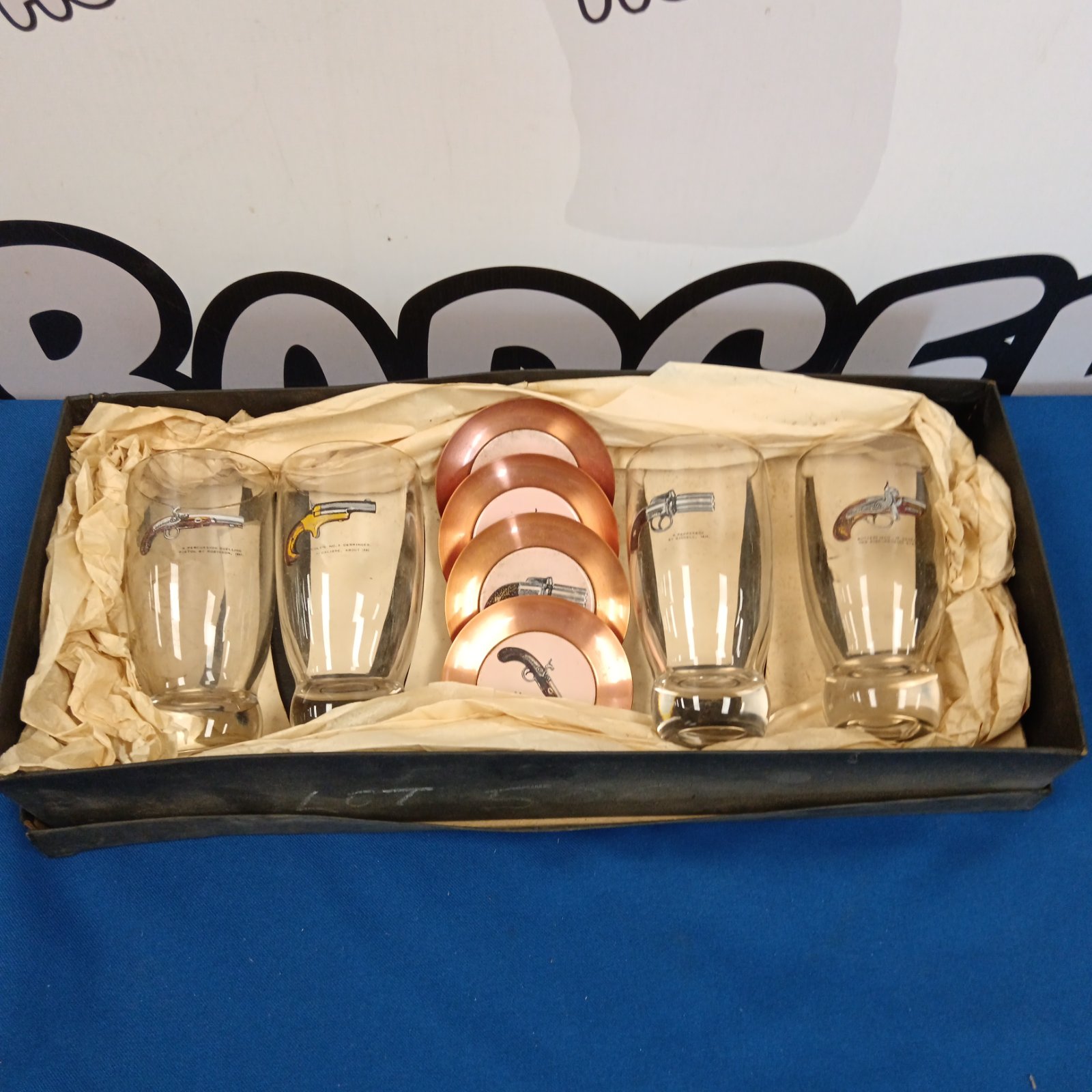 Vintage set of four copperware pistol glasses and coasters.