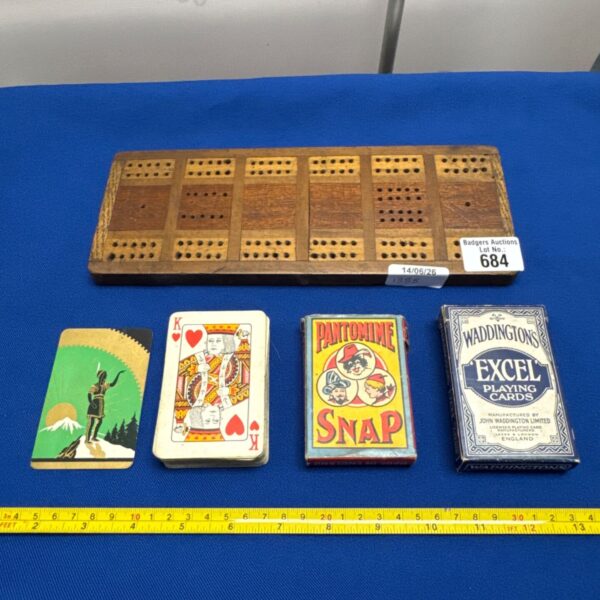 Vintage playing cards and wooden scoreboard for antique card games.