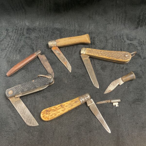 Vintage pocket knives with bone handles and multiple blades.