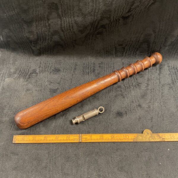 Vintage police truncheon and Acme whistle, collectible law enforcement equipment.