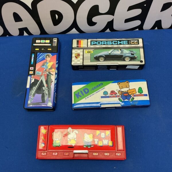 Lot of four vintage Porsche pencil cases with classic car designs.