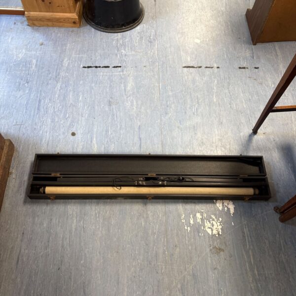 Vintage projector screen rolled up inside its original case.