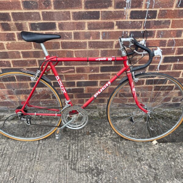 Vintage red Puch road bike with lugged steel frame.