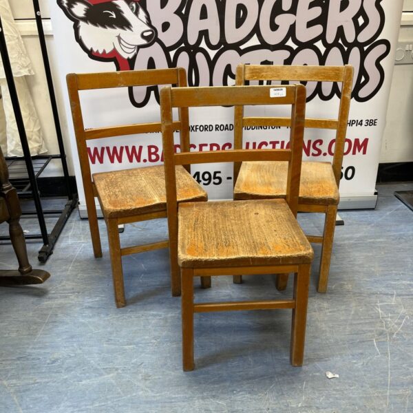 Set of three vintage wooden school chairs with slatted backs.