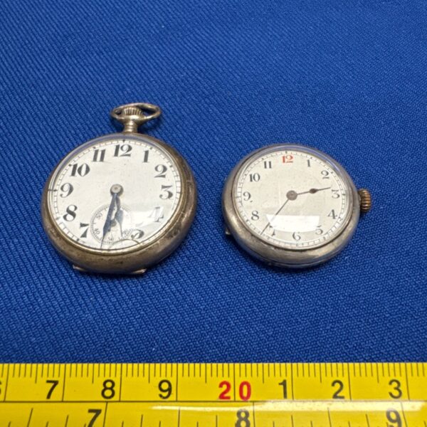 Pair of vintage silver pocket watches on blue background.