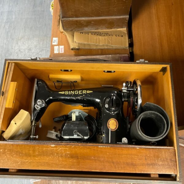 Vintage Singer sewing machine in a worn carry case.