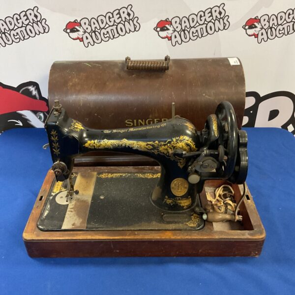 Vintage Singer sewing machine with hand crank, antique collectible.