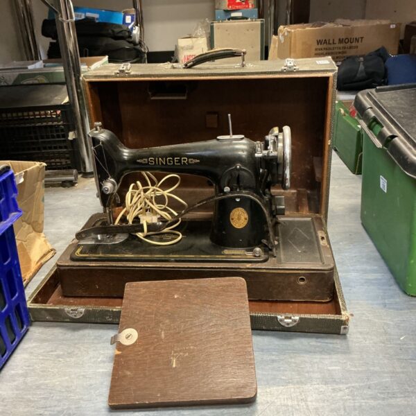 Vintage Singer sewing machine with motor and light, side view.