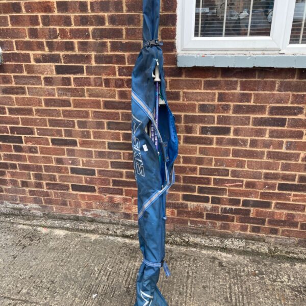 Blue vintage ski bag with white stripe, showing signs of wear.