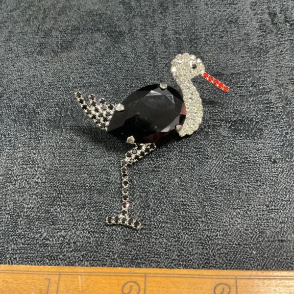 Vintage stork brooch with red and white rhinestones, a collectible pin.