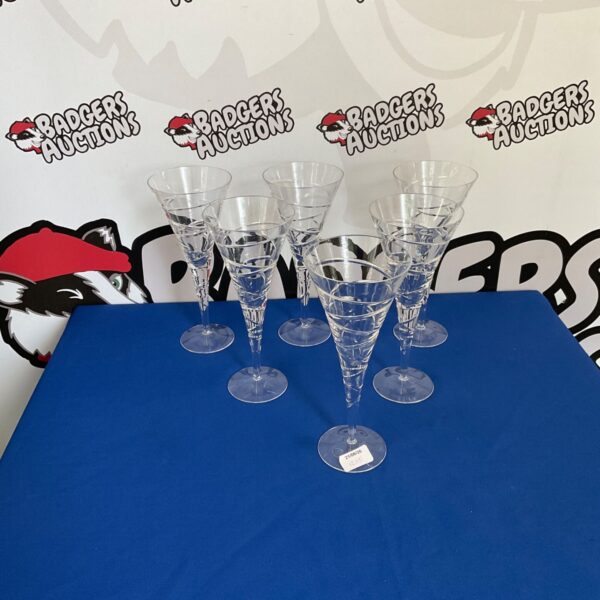Six vintage sundae glasses displayed on a surface.