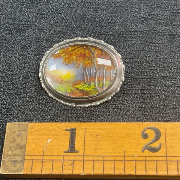 Vintage Thomas L Mott brooch with a landscape scene.