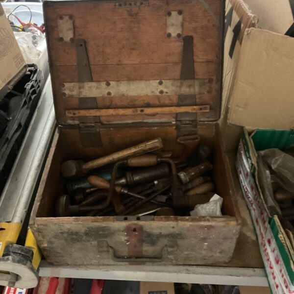 Vintage wooden tool box filled with antique tools.
